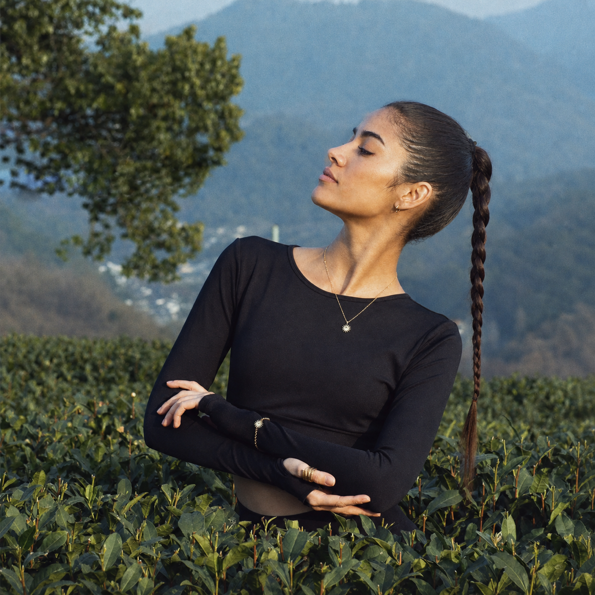 Latina model wearing gold Solstice Sun pendant necklace outdoors
